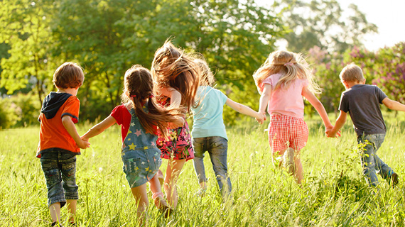 Kinder rennen über eine grüne Wiese